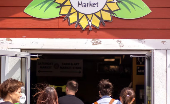 Group of people walking through the enterance to the Wolfville Farmers Market